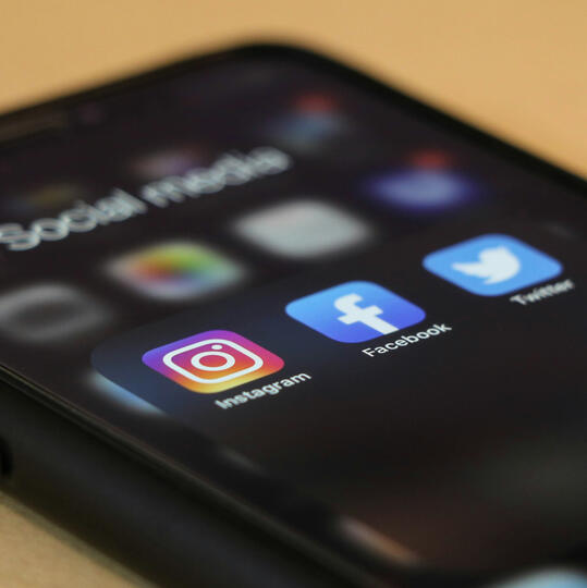 Post on social media An image of a phone with social media icons.